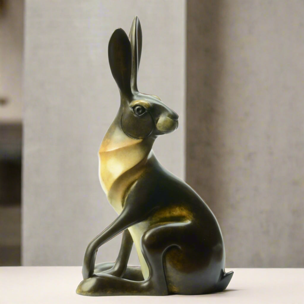 Smooth patinated bronze sculpture of a sitting hare looking to the right