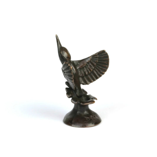 Side view of a miniature bronze kingfisher sculpture on a white background