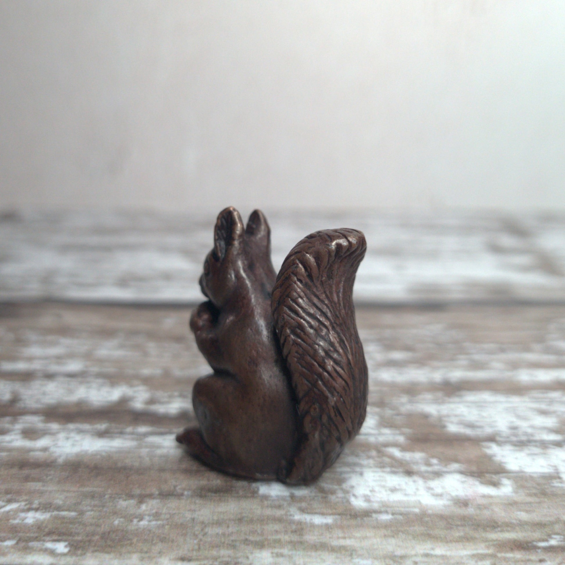 Miniature foundry-cast bronze squirrel eating an acorn, dark patina, by David Meredith at Alcove Art