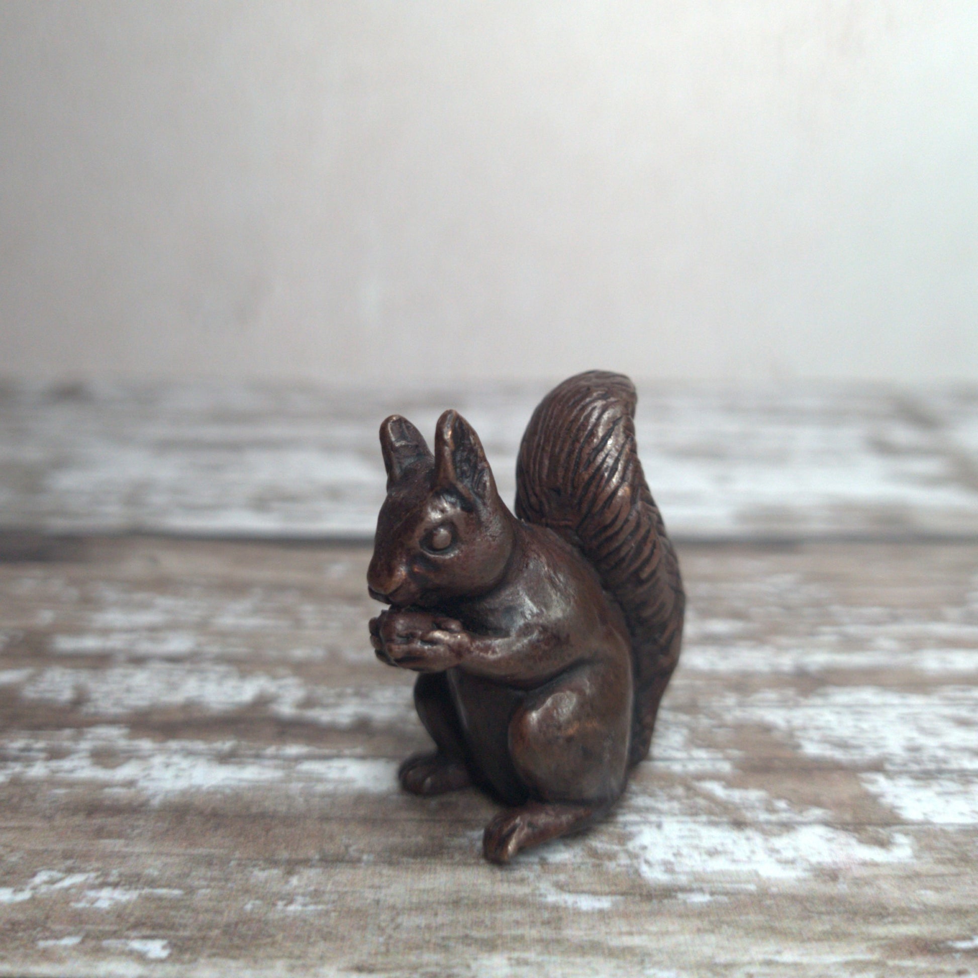 Miniature foundry-cast bronze squirrel eating an acorn, dark patina, by David Meredith at Alcove Art